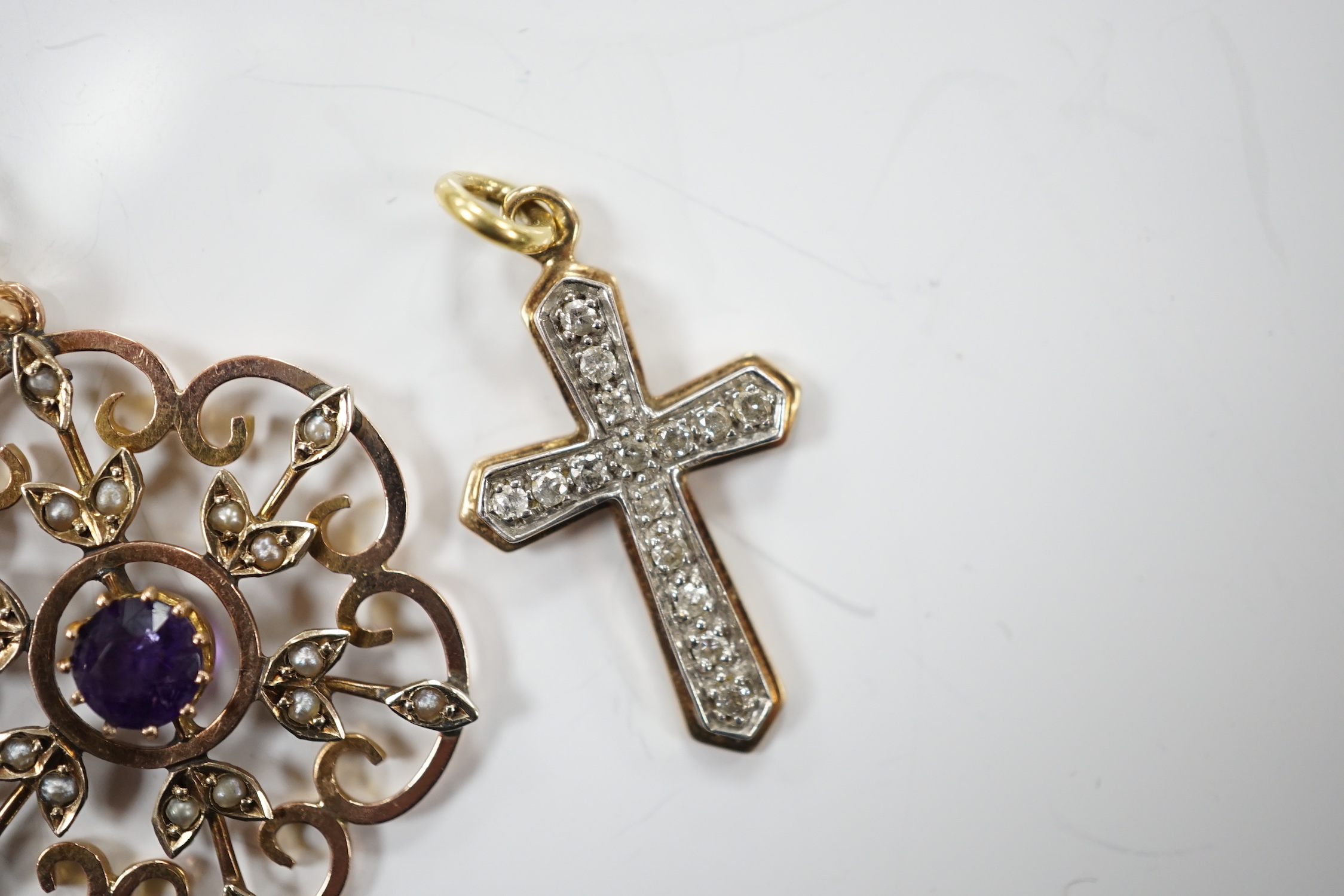 An early 20th century yellow metal, amethyst and seed pearl set pendant, 32mm, on a gilt metal chain, together with a modern yellow metal and diamond set cross pendant.